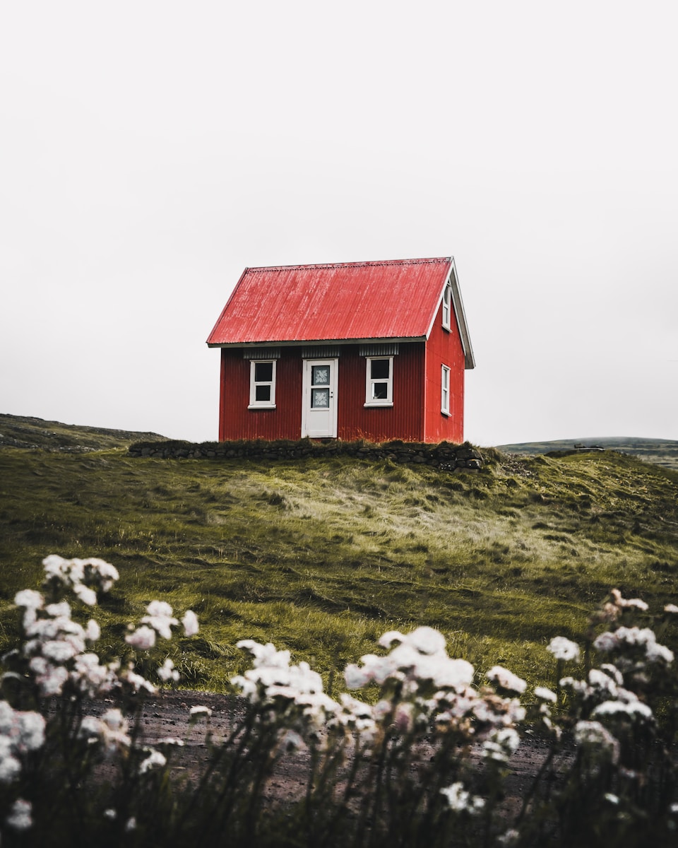 red and white house surround with homeowners insurance green grass field